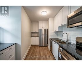 A kitchen with white cabinets and a stainless steel refrigerator.