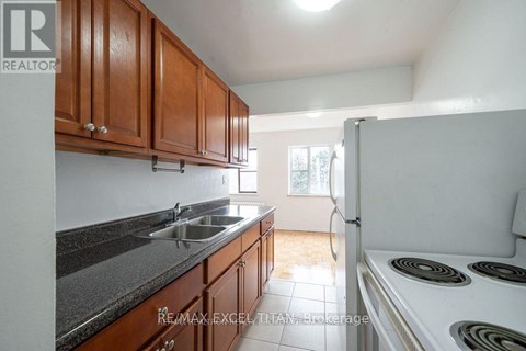 A kitchen with brown cabinets and a white stove top oven.