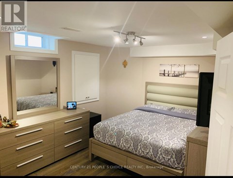 A bedroom with a bed, nightstand, and a mirror.