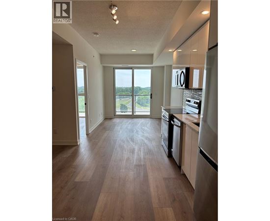 A kitchen with a refrigerator, dishwasher, and oven.