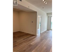 A room with wood flooring and a doorway leading to another room.