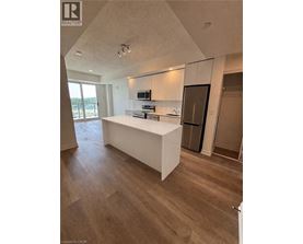 A modern kitchen with a white island and wooden flooring.