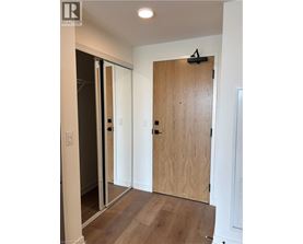 A wooden door is closed in a room with white walls.