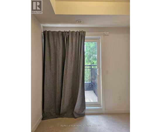 A room with a sliding glass door covered by a curtain.