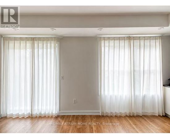 A room with white curtains and wooden floors.
