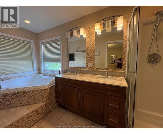 A bathroom with a large tub and a double sink vanity.