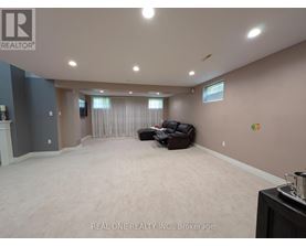 A spacious room with a couch and a fireplace.