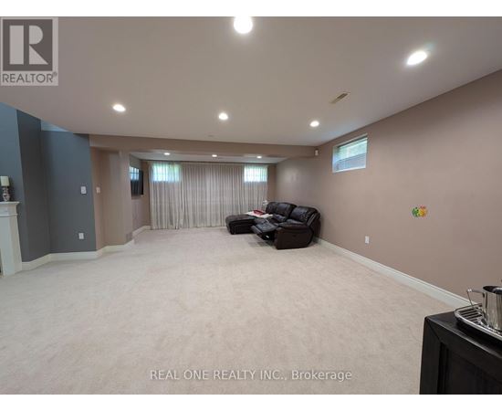 A spacious room with a couch and a fireplace.