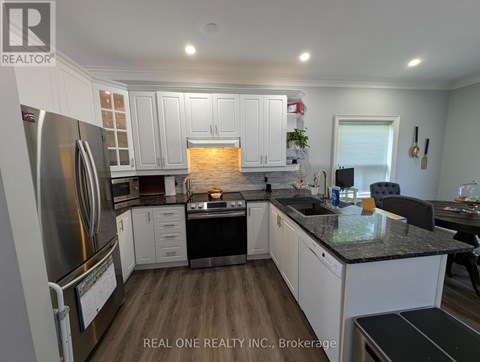A modern kitchen with white cabinets and a black countertop.