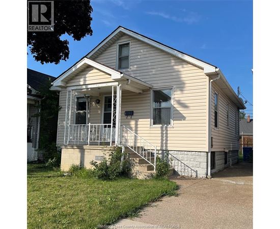 A small house with a porch and a sign that says REALTOR.