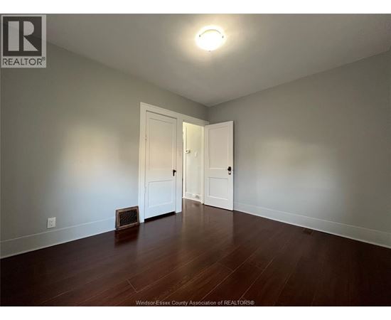 A room with a wooden floor and a white door.
