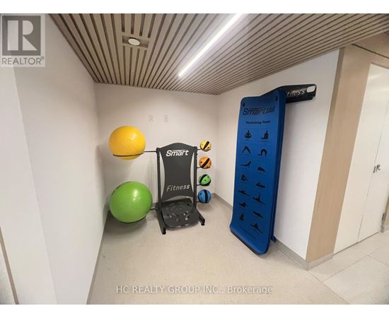 A room with a treadmill, exercise balls and a sign that says Smart Fitness.