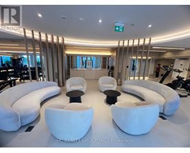A modern room with white furniture and a green exit sign.