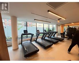 A gym with treadmills and a person walking by.