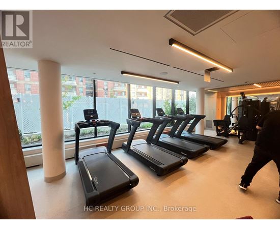 A gym with treadmills and a person walking by.