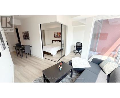 A bedroom with a bed, desk, and chair.
