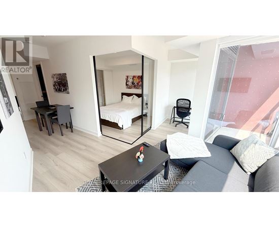A bedroom with a bed, desk, and chair.