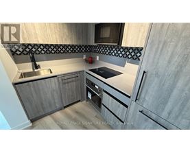 A modern kitchen with wooden cabinets and a stainless steel sink.