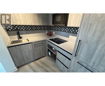 A modern kitchen with wooden cabinets and a stainless steel sink.