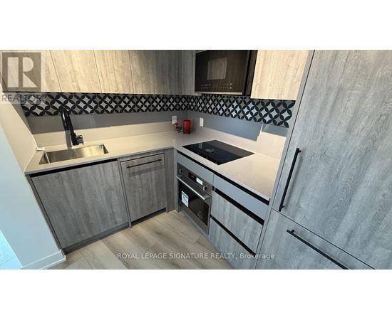 A modern kitchen with wooden cabinets and a stainless steel sink.