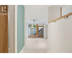 A hallway with a door at the end and a REALTOR sign on the door.