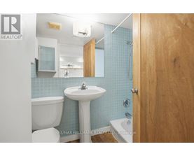 A bathroom with blue tiles and a white sink.