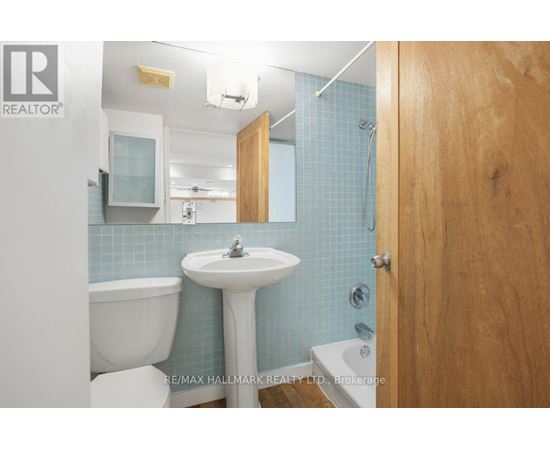 A bathroom with blue tiles and a white sink.