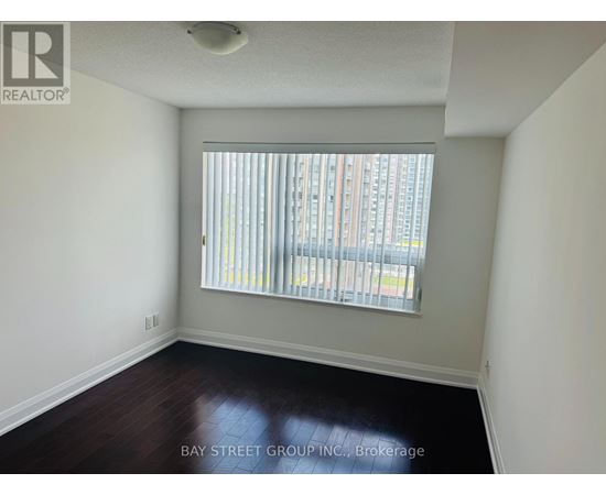 A room with a window and a wooden floor.
