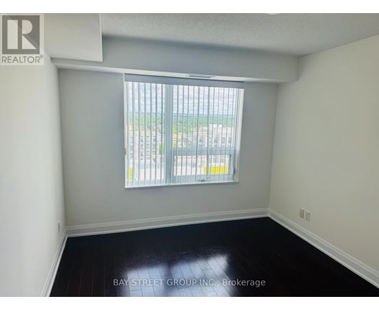 A room with a window overlooking a parking lot.