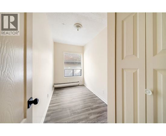A hallway with a door on the left and a window on the right.