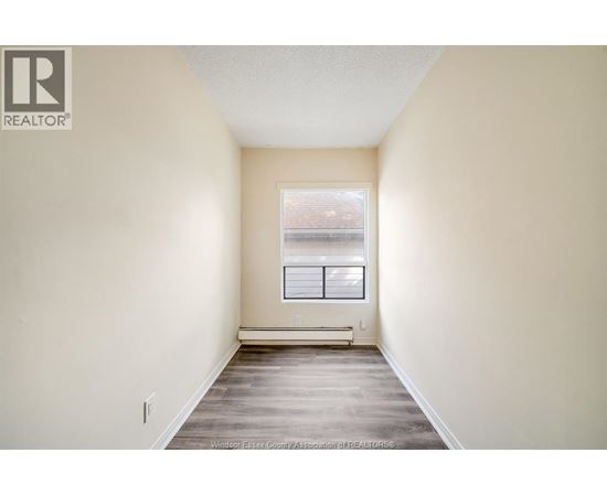 A room with a window and a bench in it.