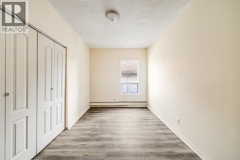 A spacious room with a door on the left and a window on the right.