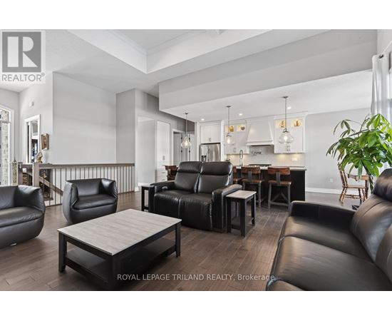 A modern living room with black leather furniture and a wooden coffee table.