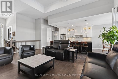 A modern living room with black leather furniture and a wooden coffee table.