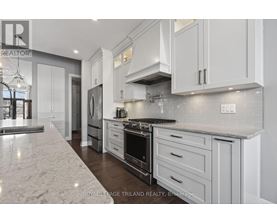 A modern kitchen with white cabinets and a marble countertop.