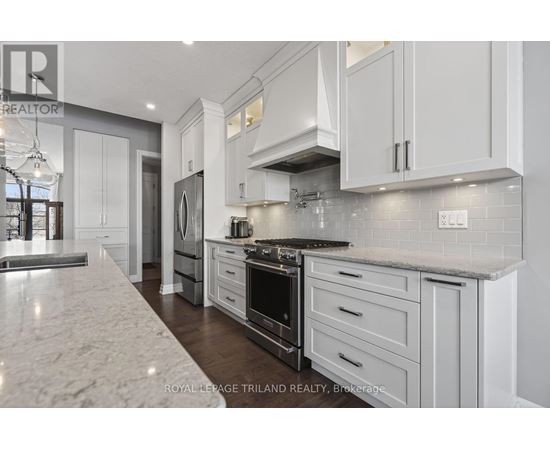 A modern kitchen with white cabinets and a marble countertop.