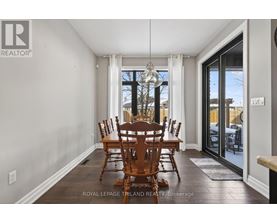 A dining room with a table and chairs.