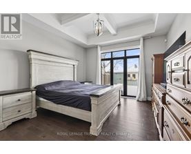 A bedroom with a large bed, wooden floors, and a dresser with a mirror.