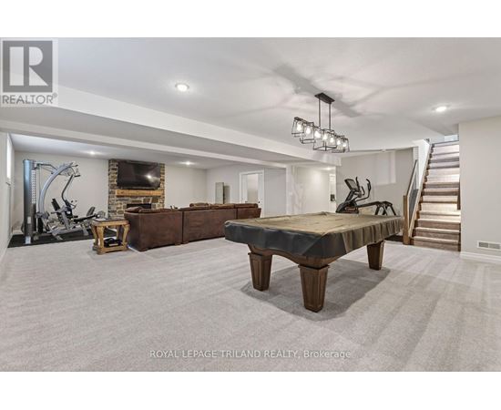 A spacious room with a gym and a staircase.