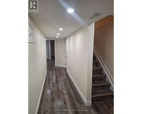 A hallway with wooden floors and a staircase.