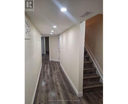 A hallway with wooden floors and a staircase.