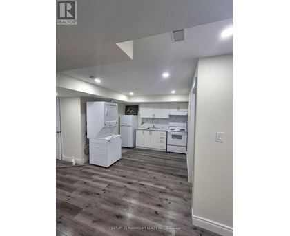 A kitchen with white appliances and wood flooring.