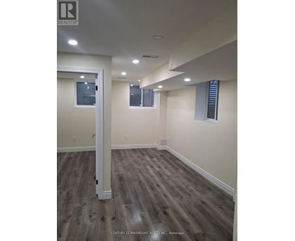 A room with wooden flooring and white walls.