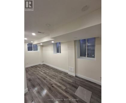 A room with wooden flooring and white walls.