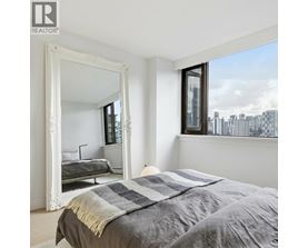 A bedroom with a large bed and a large mirror.