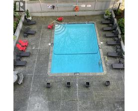 A small pool surrounded by chairs and plants.