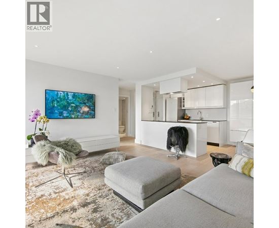 A modern living room with a grey sofa and a painting on the wall.