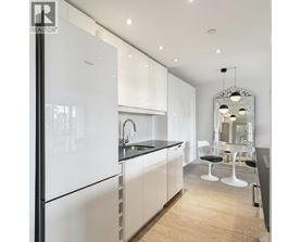 A modern kitchen with white cabinets and a black countertop.