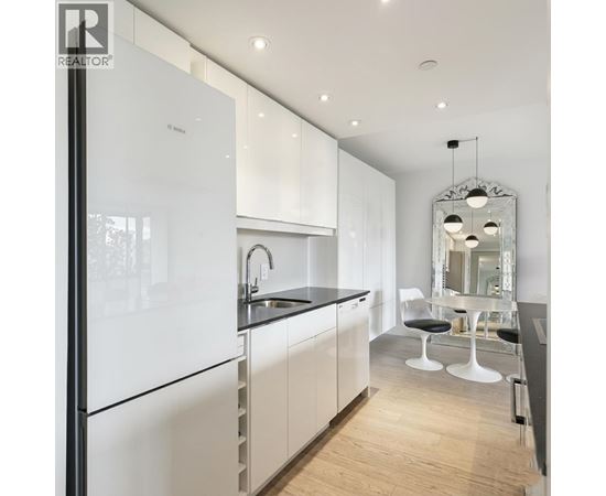 A modern kitchen with white cabinets and a black countertop.