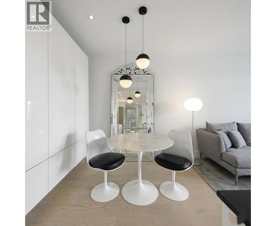 A modern dining room with a white table and chairs.